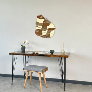Wooden Uruguay map above a desk with a stool in front