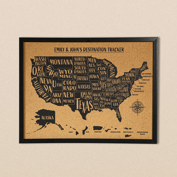 Black-framed cork USA map with state names printed in black, titled Emily & John's Destination Tracker, front view