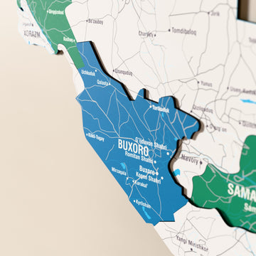 Close-up of the Flag colored Uzbekistan wooden wall map with layered regions and printed names