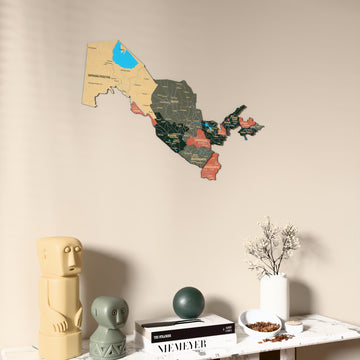 Sage Uzbekistan wooden wall map on a beige wall above a console with figurines