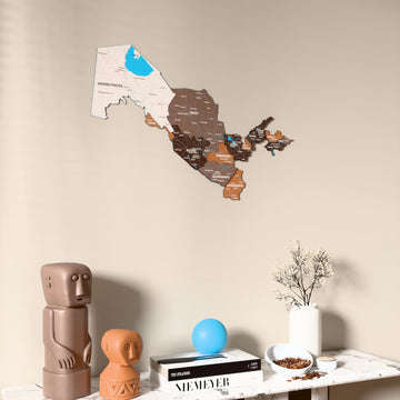 Soil Uzbekistan wooden wall map on a beige wall above a console with figurines