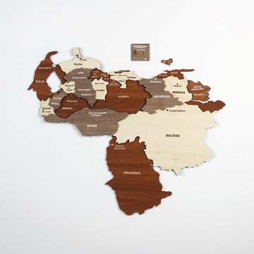 Wooden Venezuela map from a distance on a white wall, with its small plaque and island pieces to the north