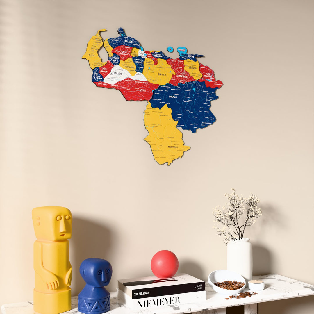 Flag colored Venezuela wooden wall map on a beige wall above a console with figurines