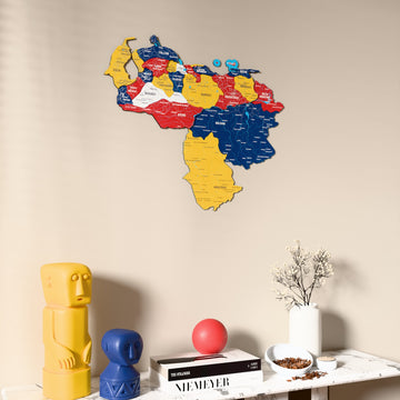 Flag colored Venezuela wooden wall map on a beige wall above a console with figurines