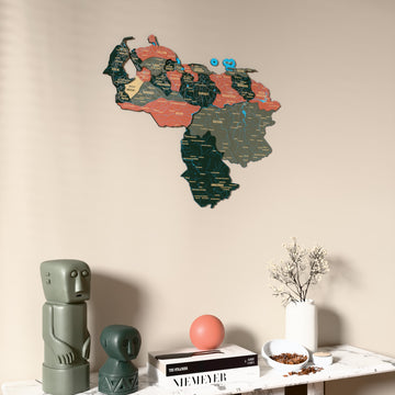 Sage Venezuela wooden wall map on a beige wall above a console with figurines