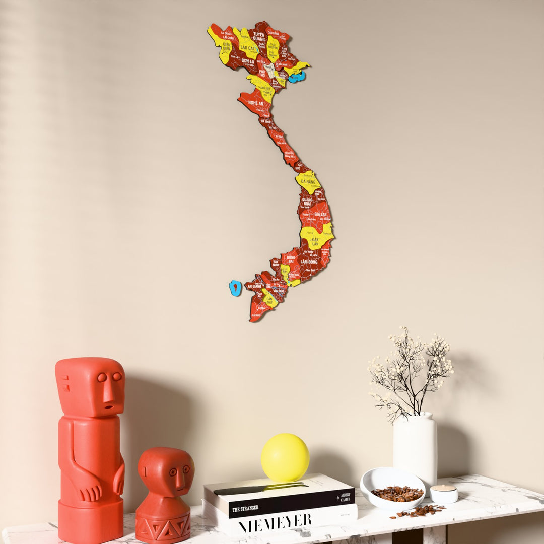 Flag colored Vietnam wooden wall map on a beige wall above a console with figurines