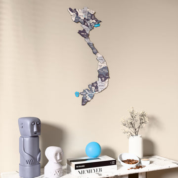 Nimbus Vietnam wooden wall map on a beige wall above a console with figurines