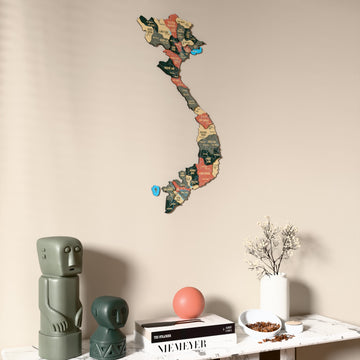 Sage Vietnam wooden wall map on a beige wall above a console with figurines