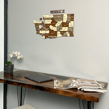 Washington State wooden wall map above the corner of a resin desk with a laptop, close view