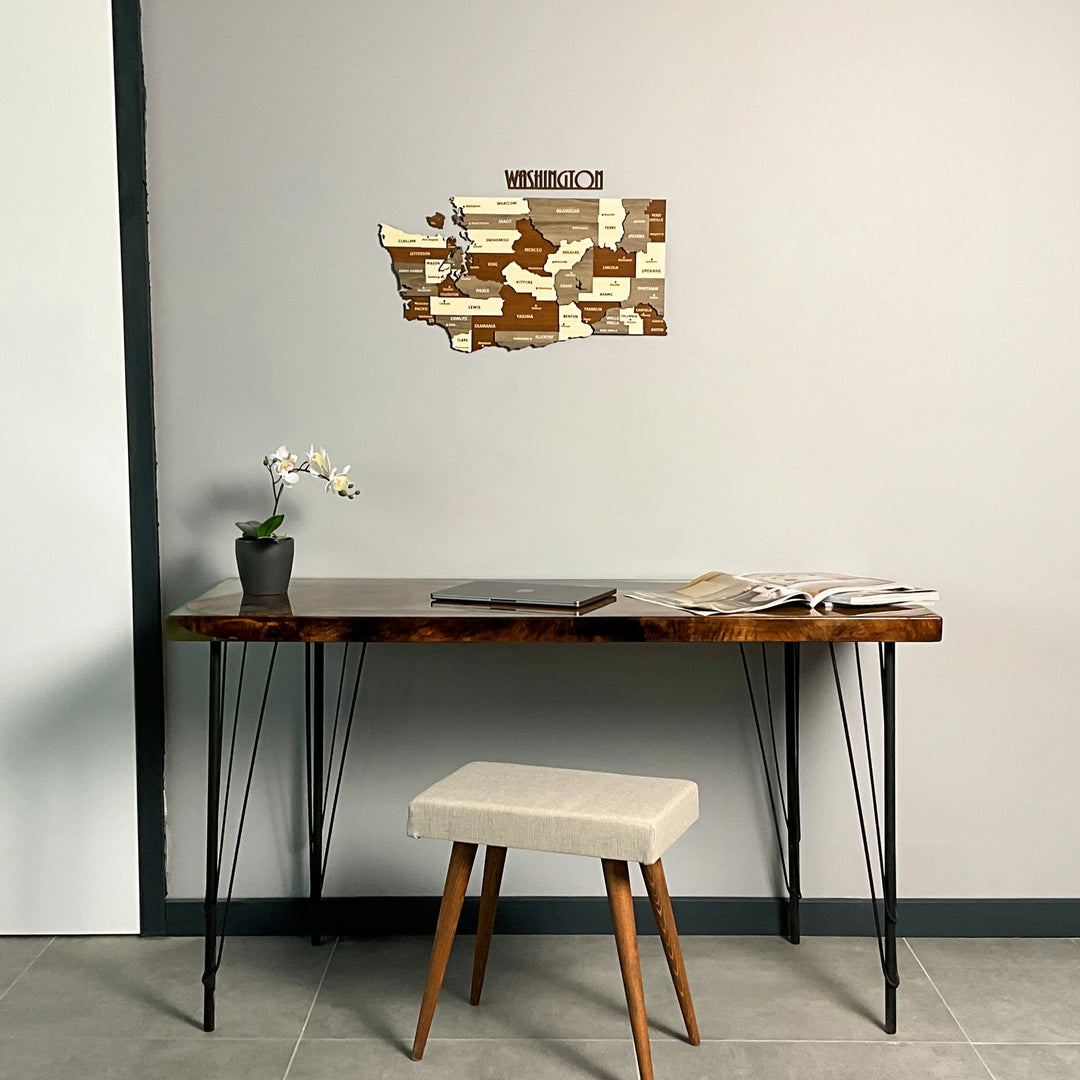Washington State wooden wall map above a resin-edged desk with an orchid, wide view