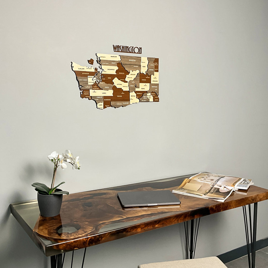 Washington State wooden wall map above a live-edge resin table with an orchid