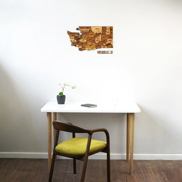 Small Washington State wooden wall map with WASHINGTON lettering above a white desk, wide view