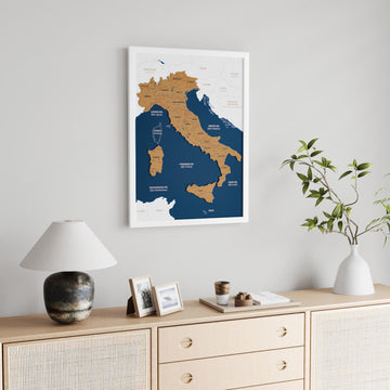 White-framed Italy cork map in a larger view, with a vase with branches on a sideboard