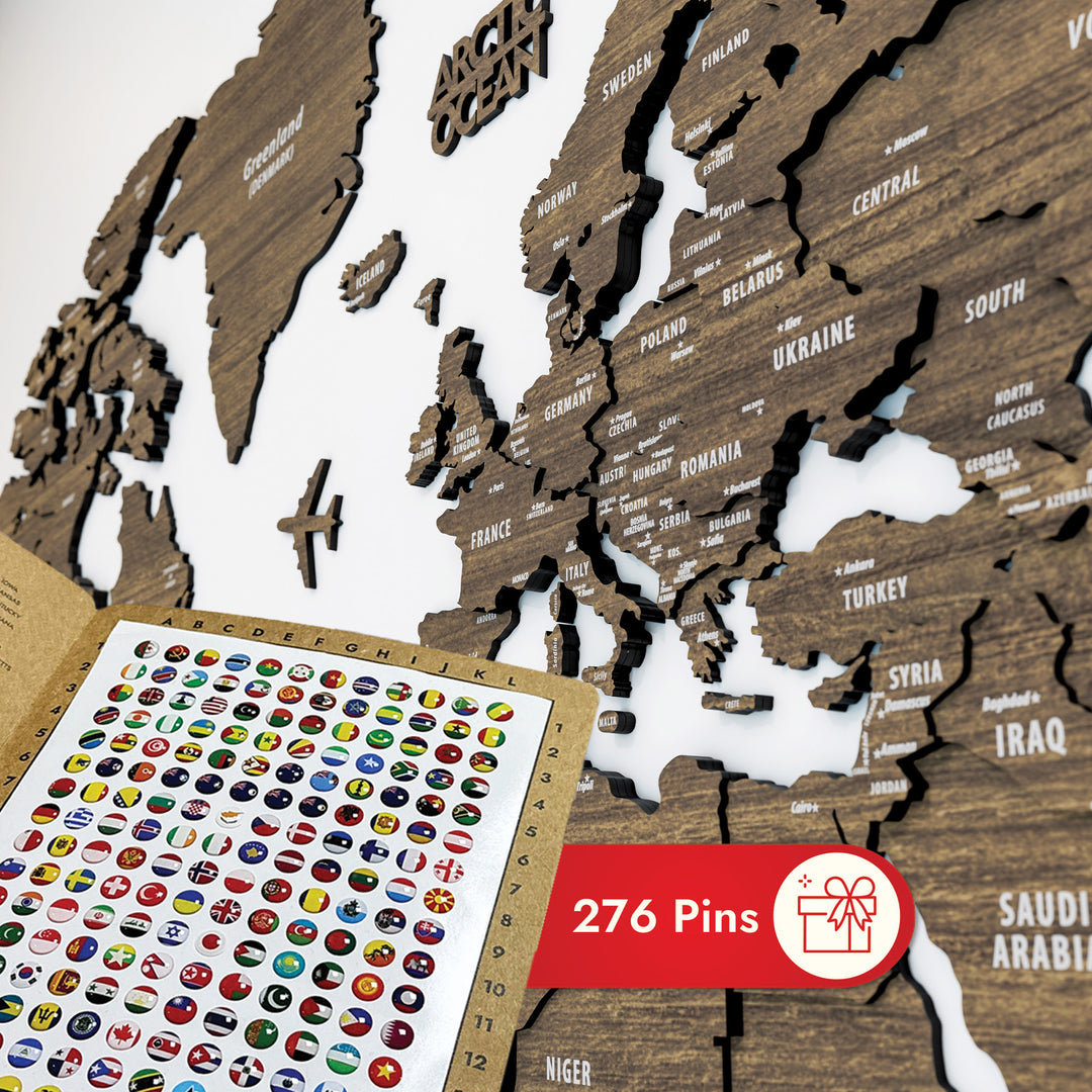 Wooden world map with pins and a sheet of country flags on a white background