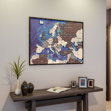Nimbus wooden Europe map hung above a dark console table with dark vases and framed photos