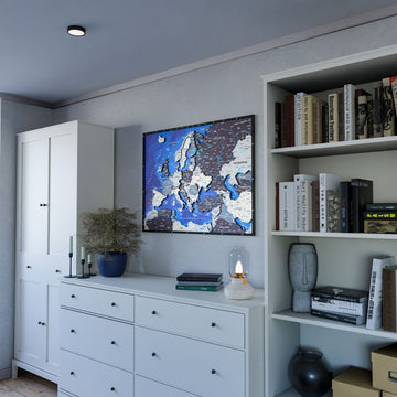 Nimbus wooden Europe map between a white wardrobe and a bookcase above a white dresser