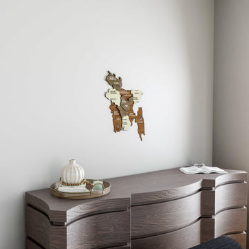 Small Bangladesh wooden wall map on a white wall above a gray wood dresser with a decorative vase