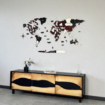 Burgundy wooden world map high on a gray wall above a river-style wood and black resin sideboard