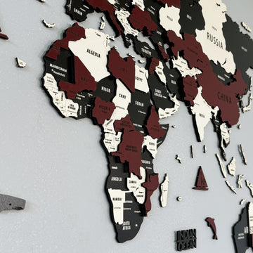 Close-up of Africa on the burgundy wooden world map with Algeria, Chad, Sudan and Namibia in layered wood
