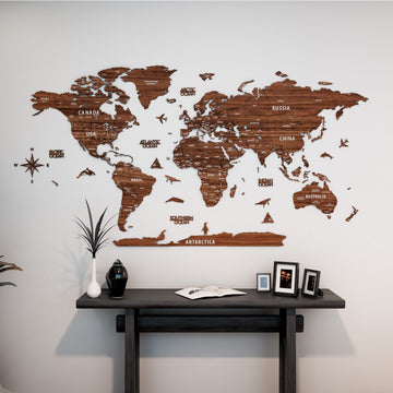 Light brown wooden world map with country names above a dark console table with framed photos