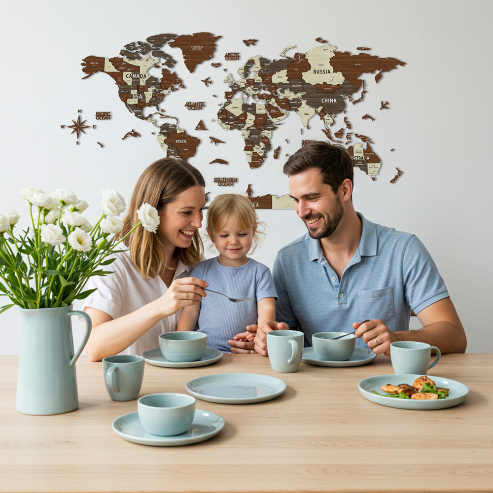 Family of three enjoying a meal together at a table with a world map in the background.