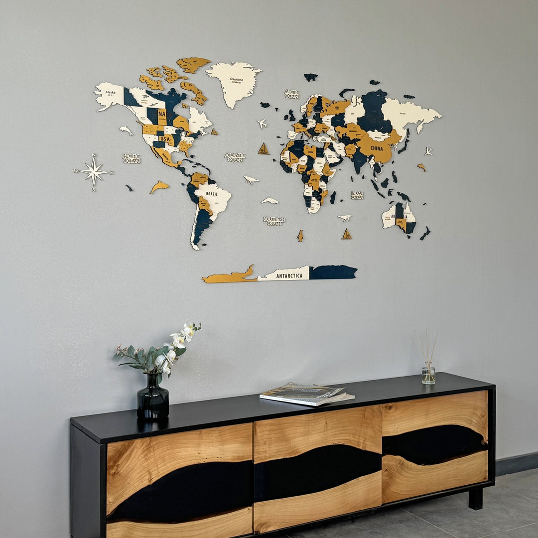 Yellow wooden world map high on a gray wall above a river-style wood and black resin sideboard