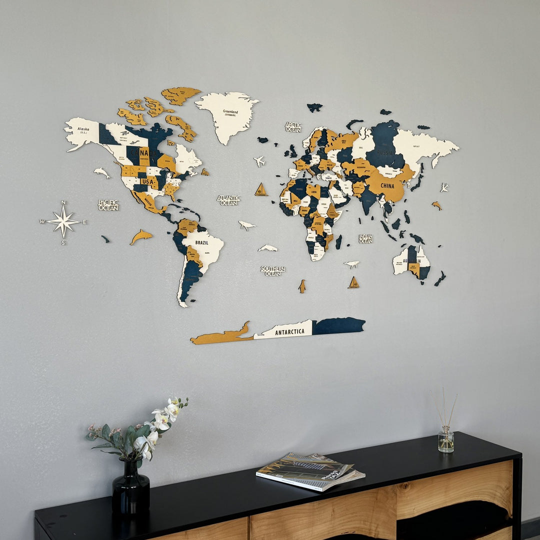 Yellow wooden world map filling the frame, with the Antarctica strip and orchids at the lower left