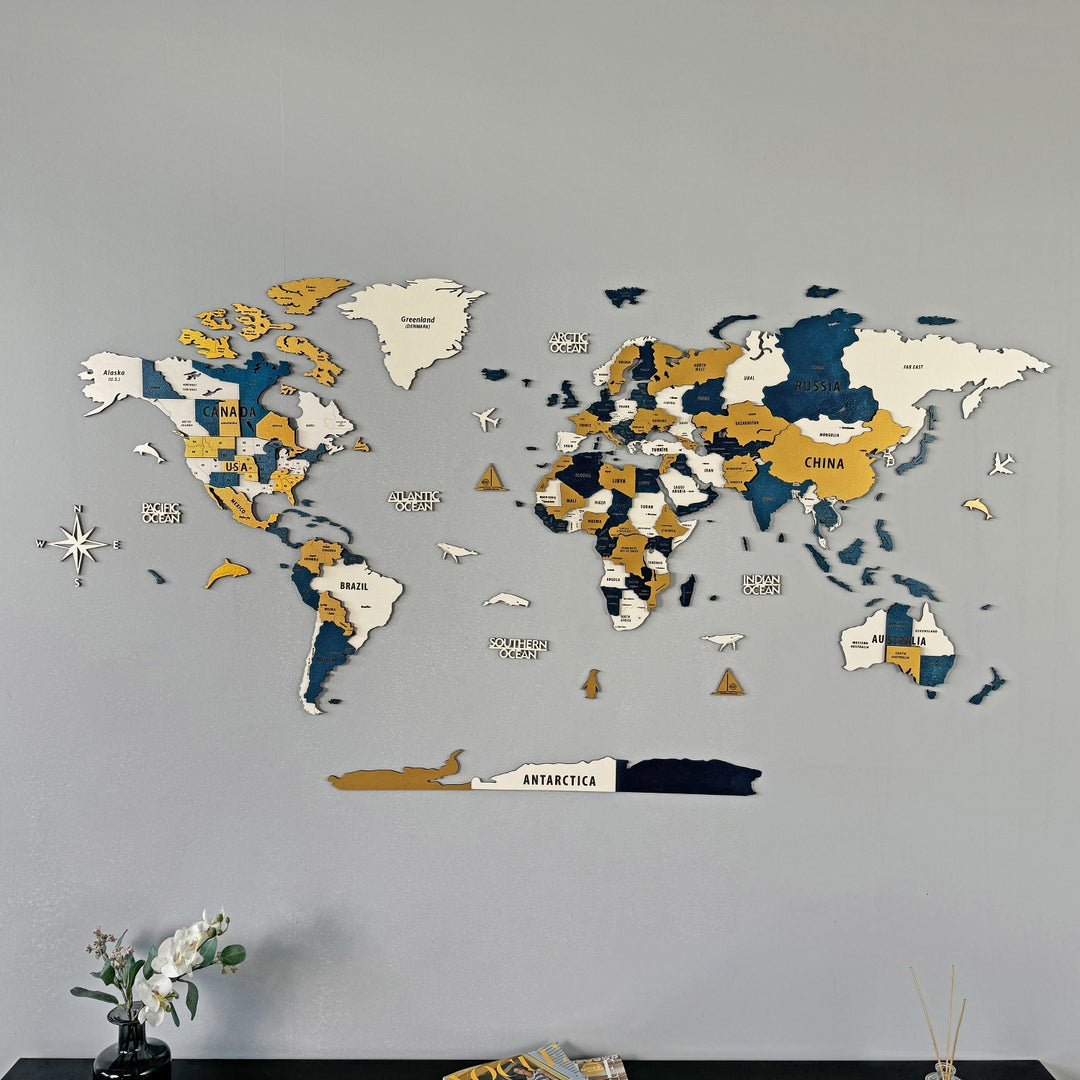 Yellow wooden world map from a slightly lower angle with a white orchid at the bottom edge