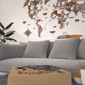 Soil wooden world map above a gray sofa, low angle with a map shipping box on the table