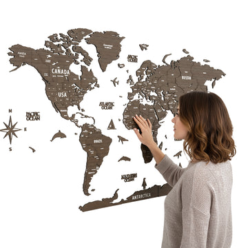 Betul wooden world map hung on a white wall, a woman touching South America