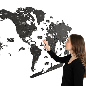 Tuana wooden world map with country names, a woman touching North America