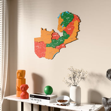Flag colored Zambia wooden wall map beside a sheer curtain, angled view