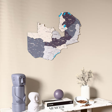 Nimbus Zambia wooden wall map on a beige wall above a console with figurines