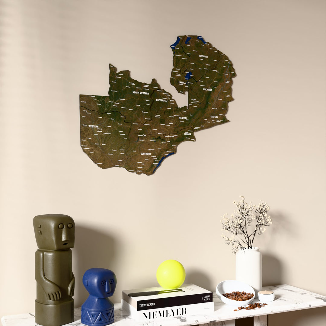 Satellite Zambia wooden wall map on a beige wall above a console with figurines
