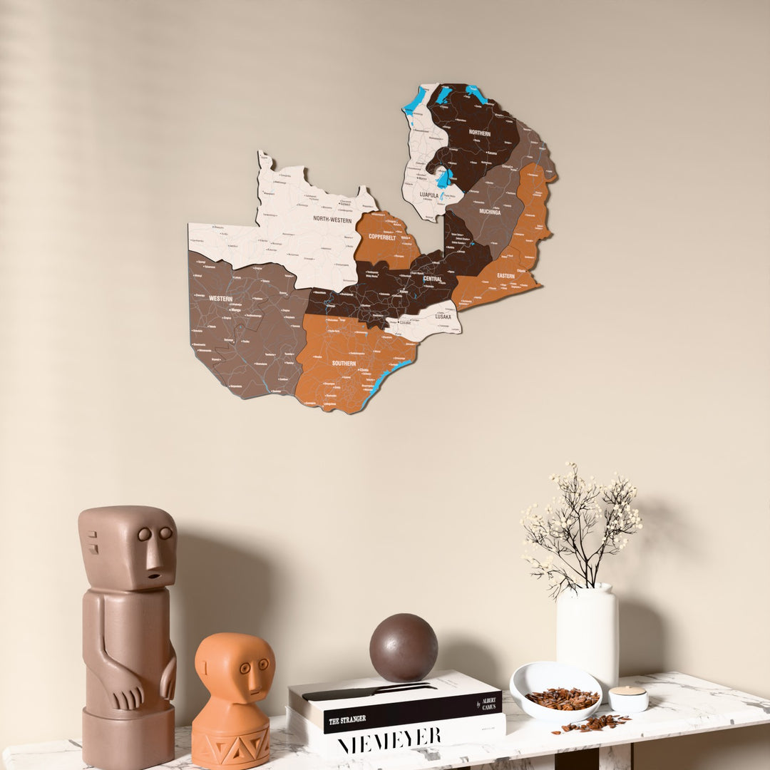 Soil Zambia wooden wall map on a beige wall above a console with figurines