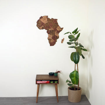 Wooden Africa wall map above a small walnut side table, wide room view