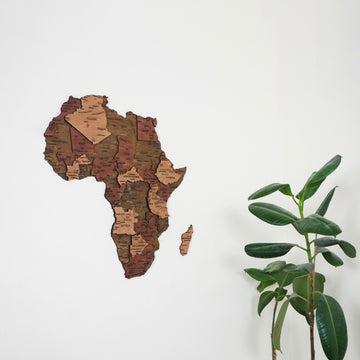 Wooden Africa wall map in brown and tan wood tones on a white wall, close view