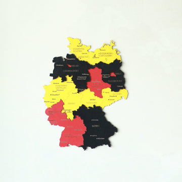 Smaller flag-colored wooden Germany map hung on a white wall, with Bavaria in black and Baden-Wurttemberg in red