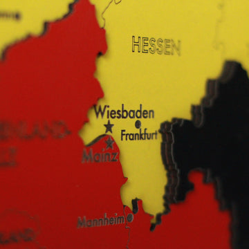 Close-up of the wooden Germany map showing Wiesbaden, Frankfurt, Mainz and Mannheim in red, yellow and black