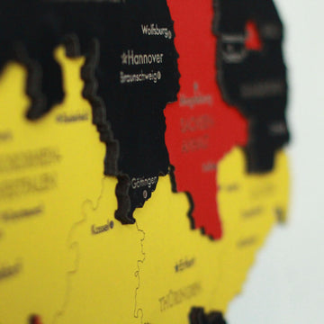 Soft-focus close-up of the wooden Germany map around Hanover and Gottingen in black, red and yellow layers