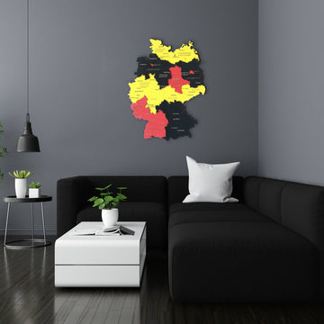 Flag-colored wooden Germany wall map in black, red and yellow in a dark living room, above a sofa