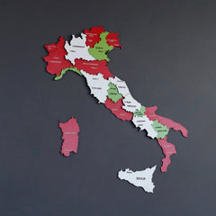 Italy flag-colored wooden wall map in red, white and green regions on a dark gray wall, front view