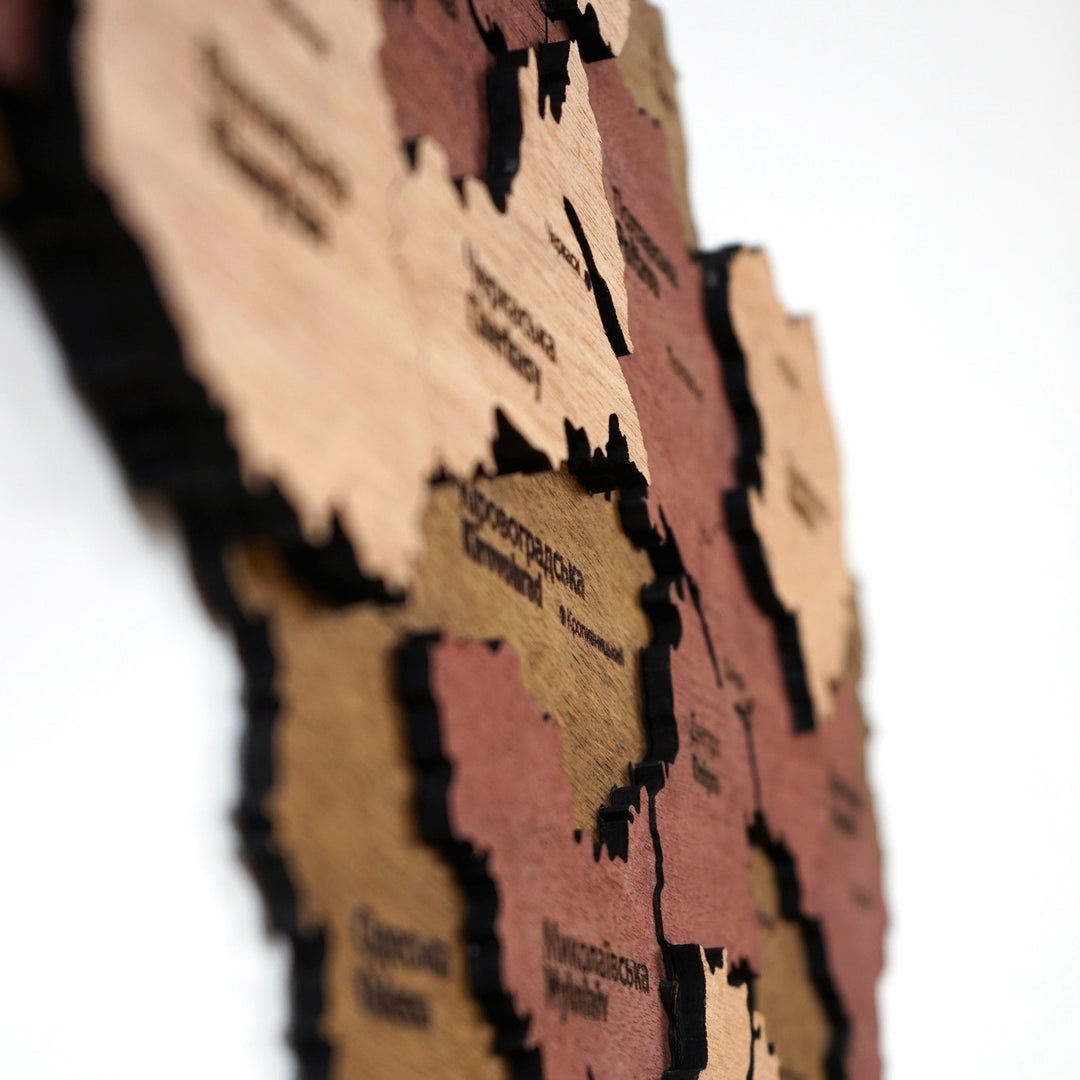 Close-up of Ukraine wooden map layers showing Cherkasy, Odesa and Mykolaiv in blurred depth