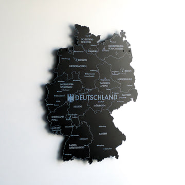 Black metal Germany map seen from an angle with a soft shadow on the white wall