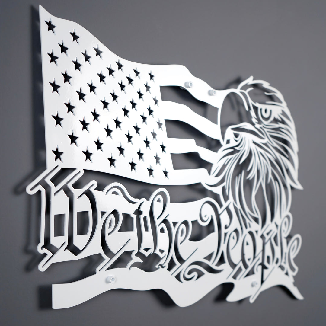 White We The People US flag metal wall art, large angled view on a dark gray wall