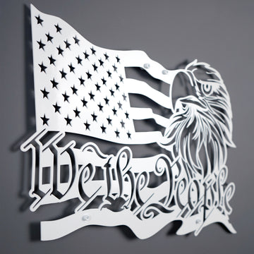 White We The People US flag metal wall art, large angled view on a dark gray wall